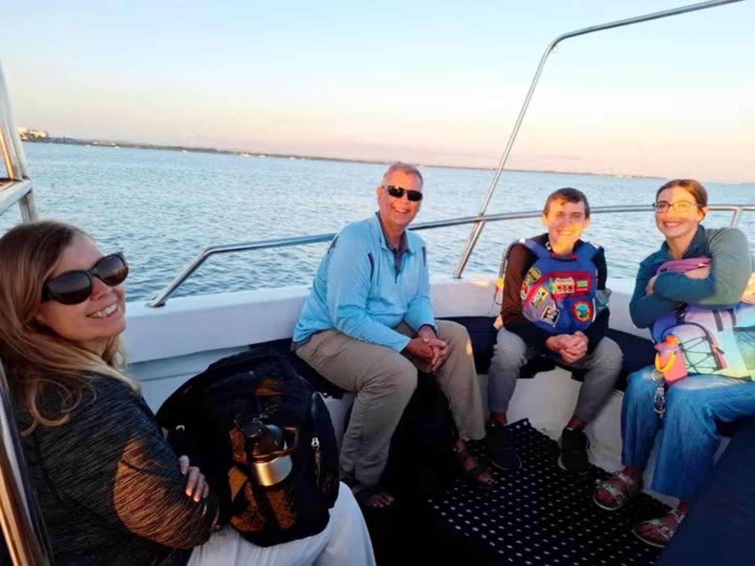 Family travelling by private boat at sunset